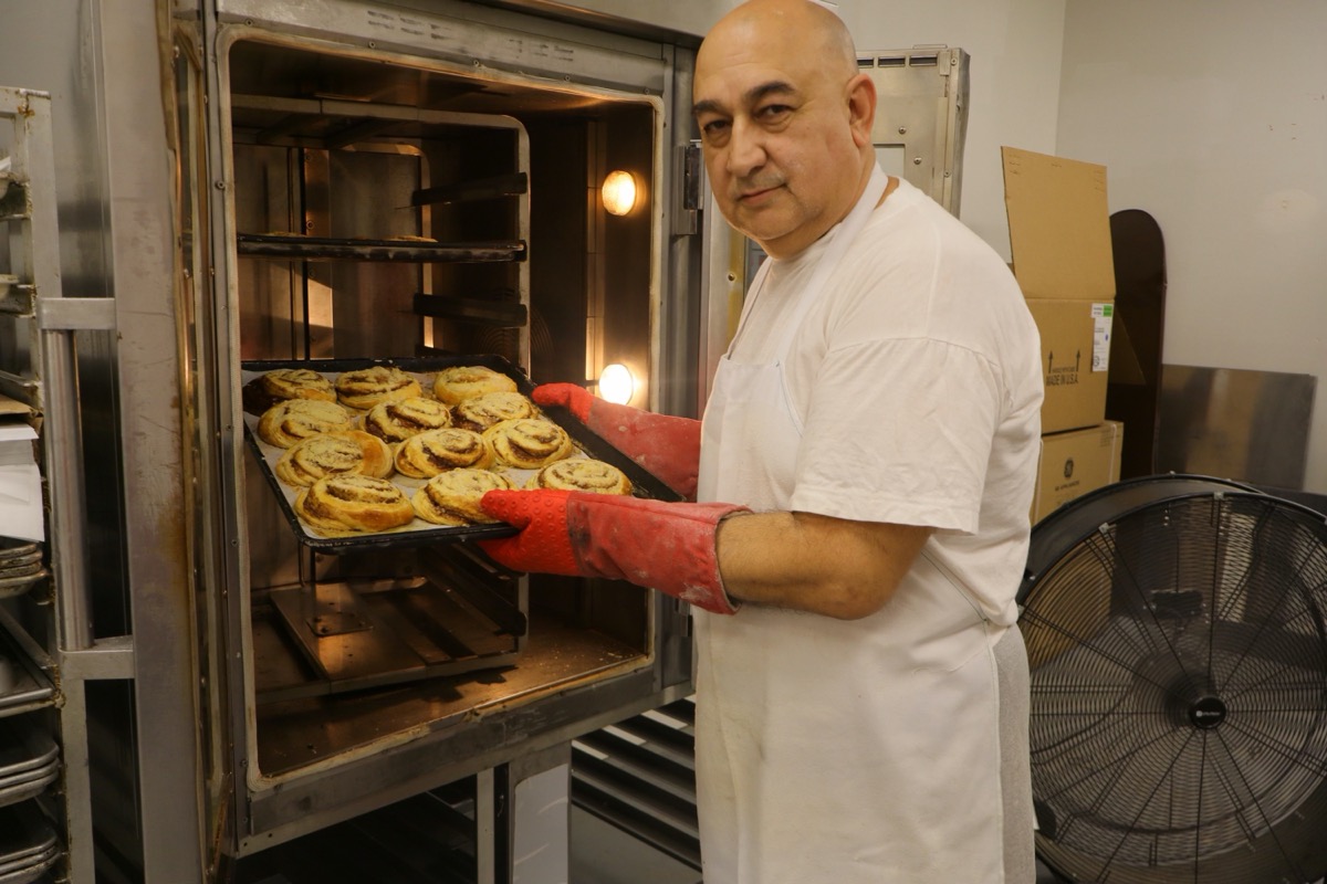 Master Baker Max at stone oven with fresh cinnamon rolls